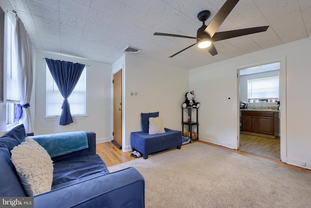 living room featuring ceiling fan, hardwood / wood-style floors, and a healthy amount of sunlight