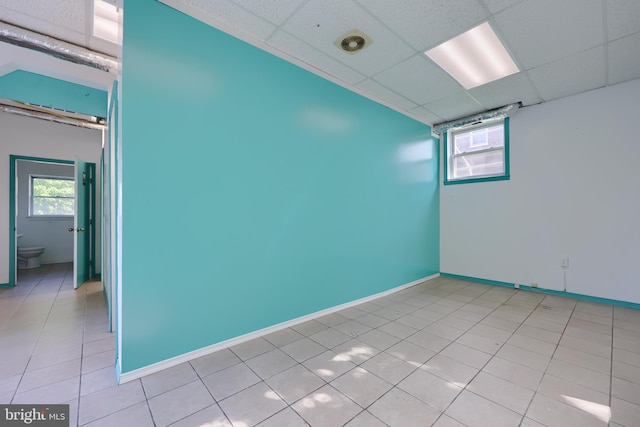 tiled empty room featuring a paneled ceiling