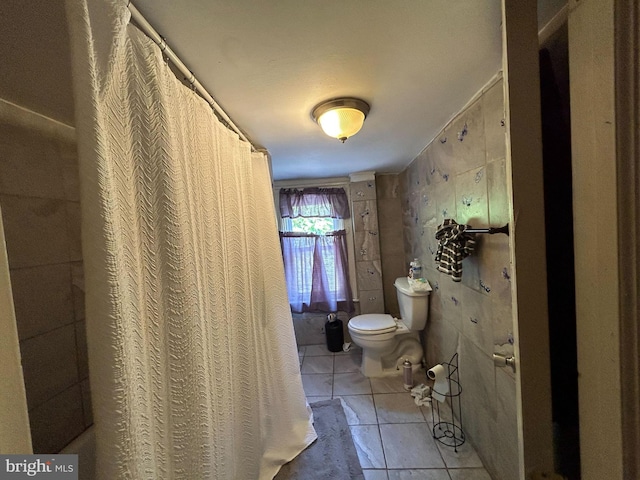 bathroom with toilet and tile patterned flooring