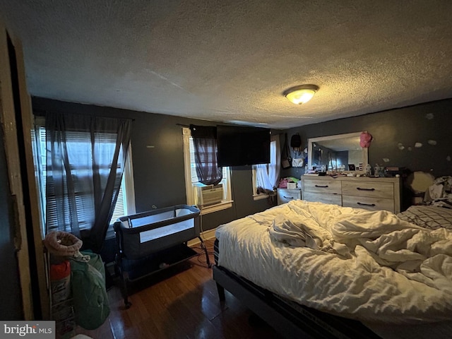 bedroom with hardwood / wood-style flooring, a textured ceiling, and cooling unit