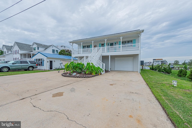 view of front of property featuring a garage, a front lawn, and a porch