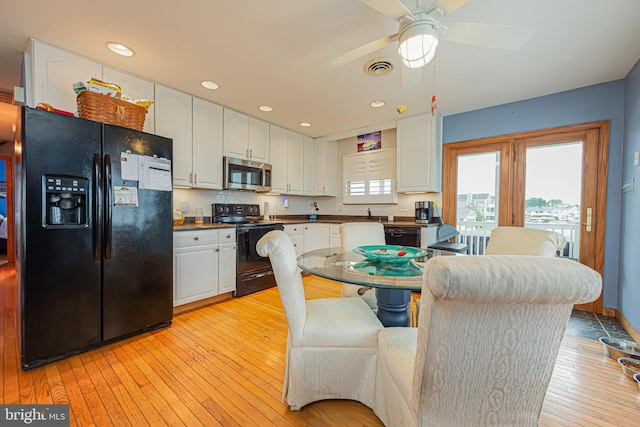 kitchen featuring white cabinetry, light hardwood / wood-style floors, ceiling fan, tasteful backsplash, and black appliances