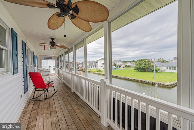 wooden deck featuring ceiling fan and a water view