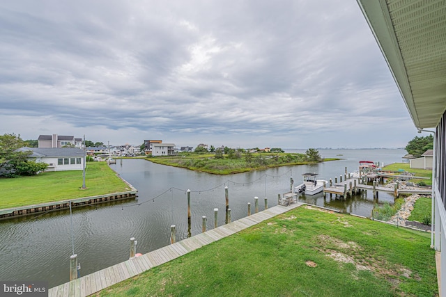 view of dock featuring a water view and a yard