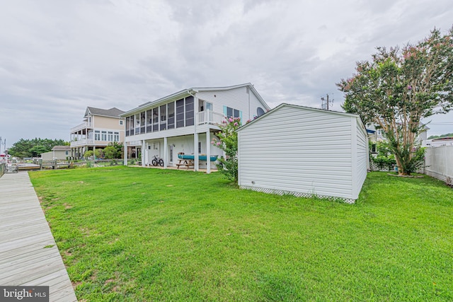 back of property featuring a sunroom and a lawn