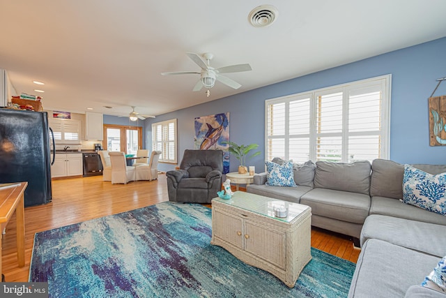 living room with ceiling fan and light wood-type flooring