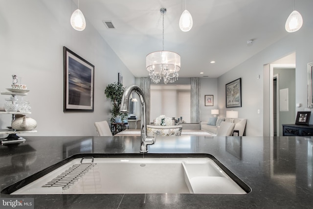 kitchen featuring a notable chandelier, pendant lighting, and sink