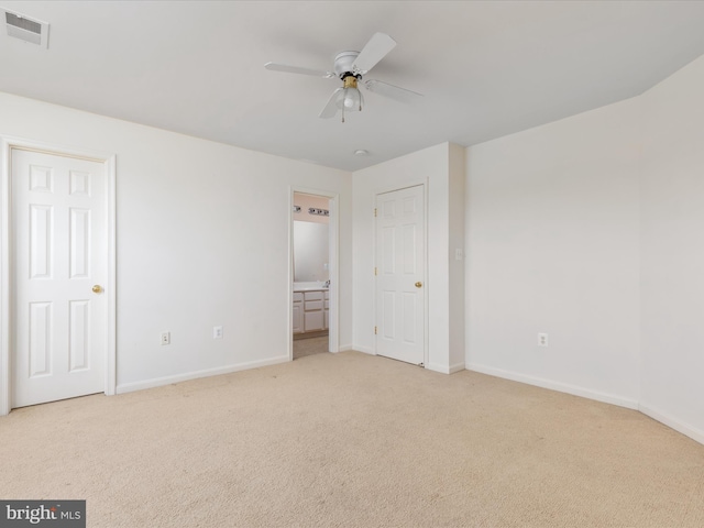 unfurnished bedroom with connected bathroom, light carpet, and ceiling fan