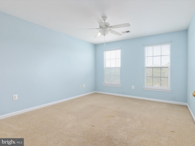 carpeted spare room featuring ceiling fan