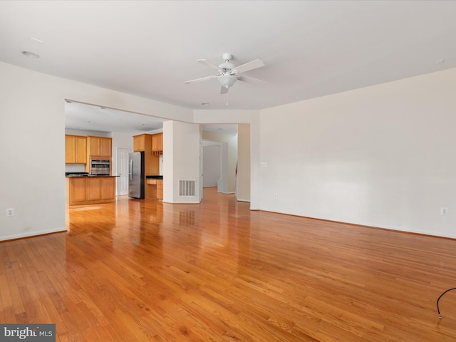 unfurnished living room featuring light hardwood / wood-style flooring and ceiling fan