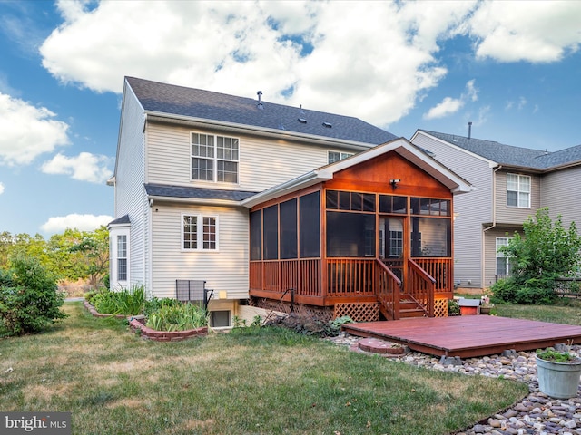 back of house featuring a wooden deck, a sunroom, and a lawn