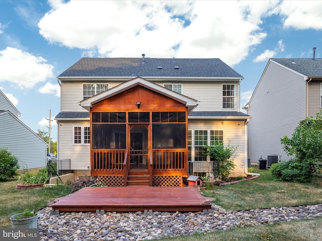 rear view of property with a wooden deck, a yard, a sunroom, and central air condition unit