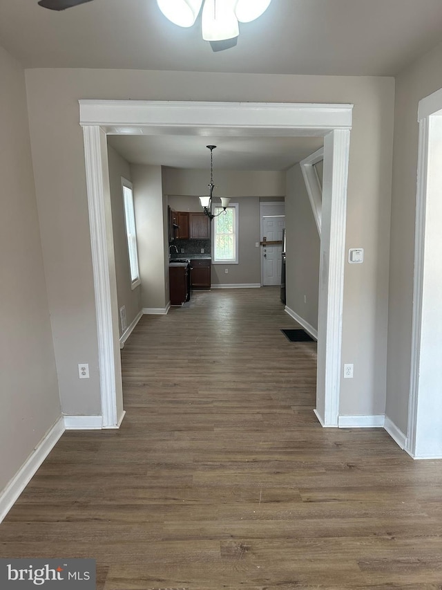 unfurnished living room with dark hardwood / wood-style floors and an inviting chandelier