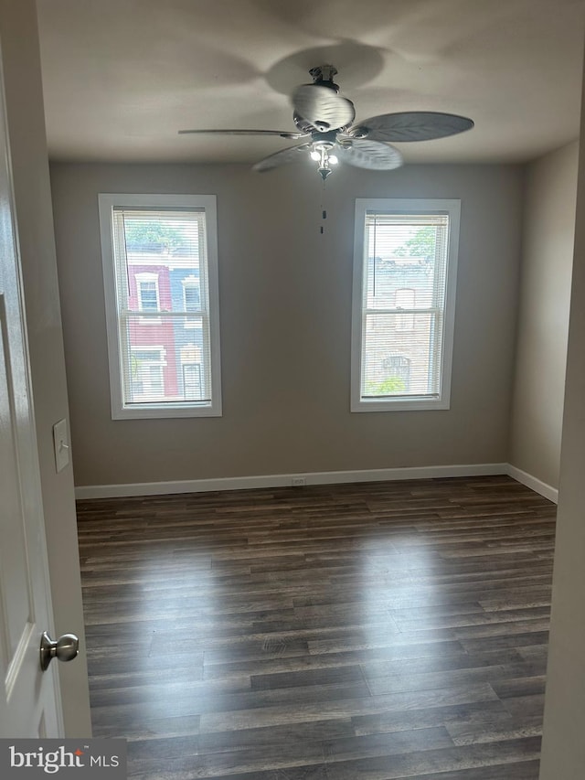 spare room featuring ceiling fan and dark wood-type flooring