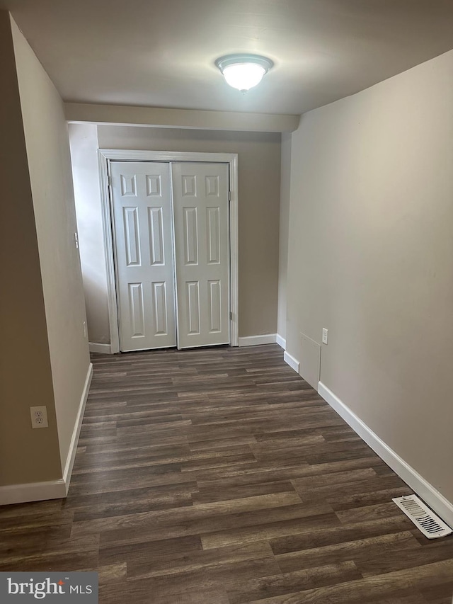 unfurnished bedroom featuring a closet and dark hardwood / wood-style floors