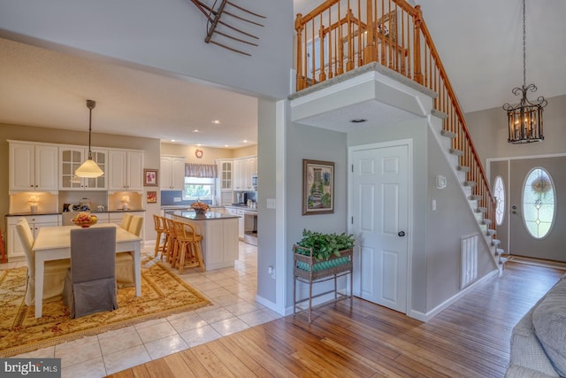 entrance foyer featuring a chandelier, light hardwood / wood-style floors, and a towering ceiling