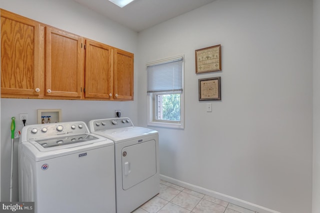 laundry area featuring light tile patterned flooring, washing machine and dryer, and cabinets