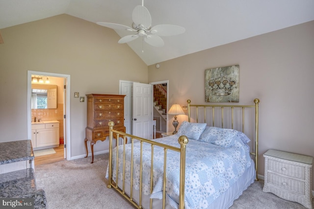 bedroom with vaulted ceiling, ensuite bath, sink, light carpet, and ceiling fan