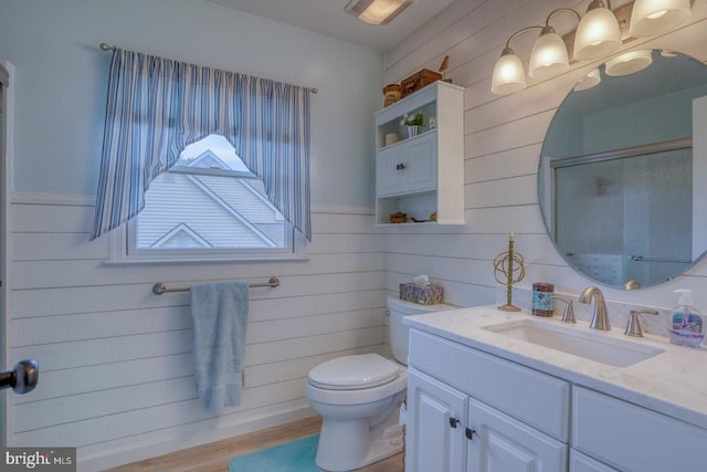 bathroom featuring vanity, toilet, wood-type flooring, and wood walls