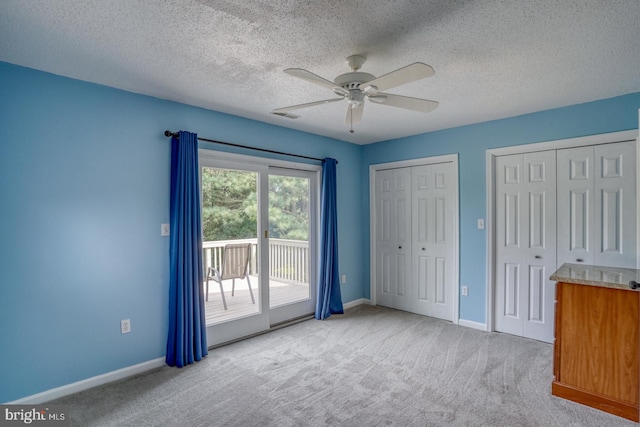 unfurnished bedroom featuring carpet flooring, a textured ceiling, ceiling fan, and access to exterior