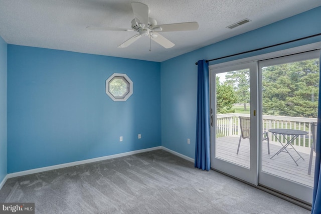 carpeted empty room with a textured ceiling and ceiling fan