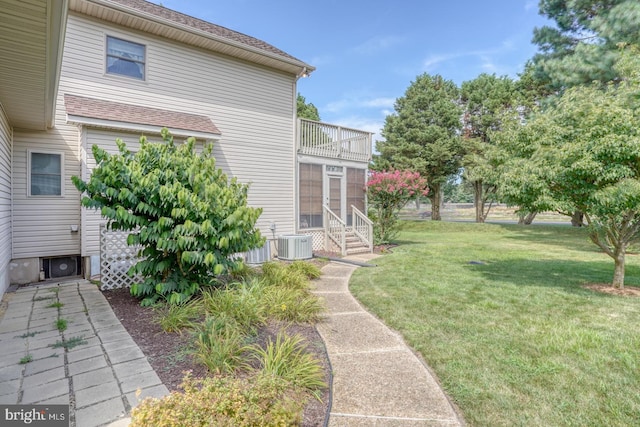 view of yard featuring a balcony and central AC unit