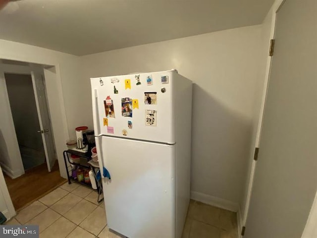 kitchen with white fridge and light tile patterned floors