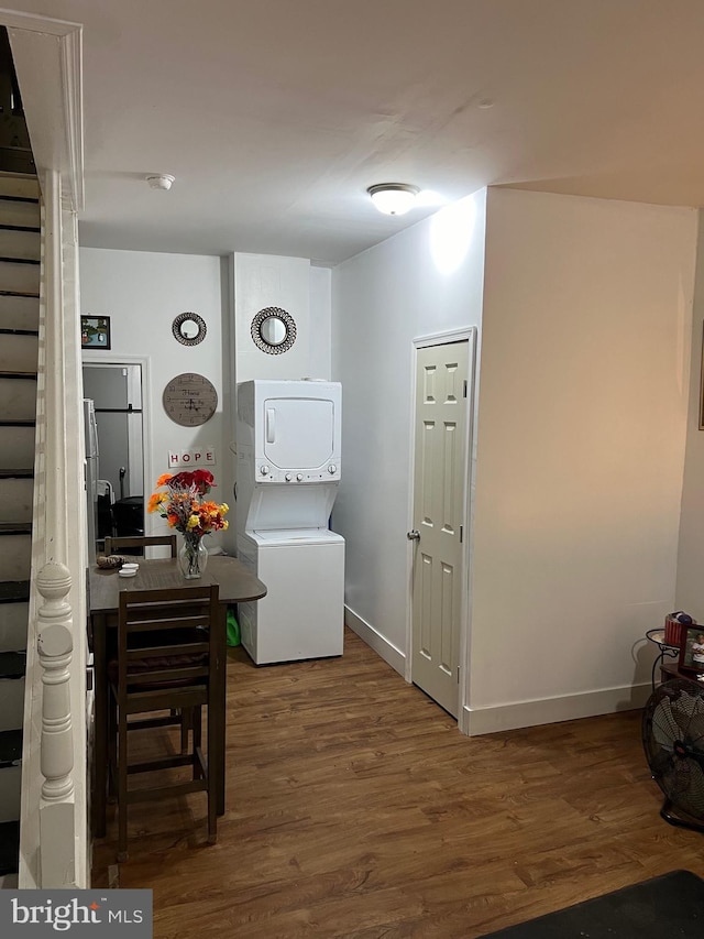 corridor featuring dark hardwood / wood-style flooring and stacked washer and clothes dryer