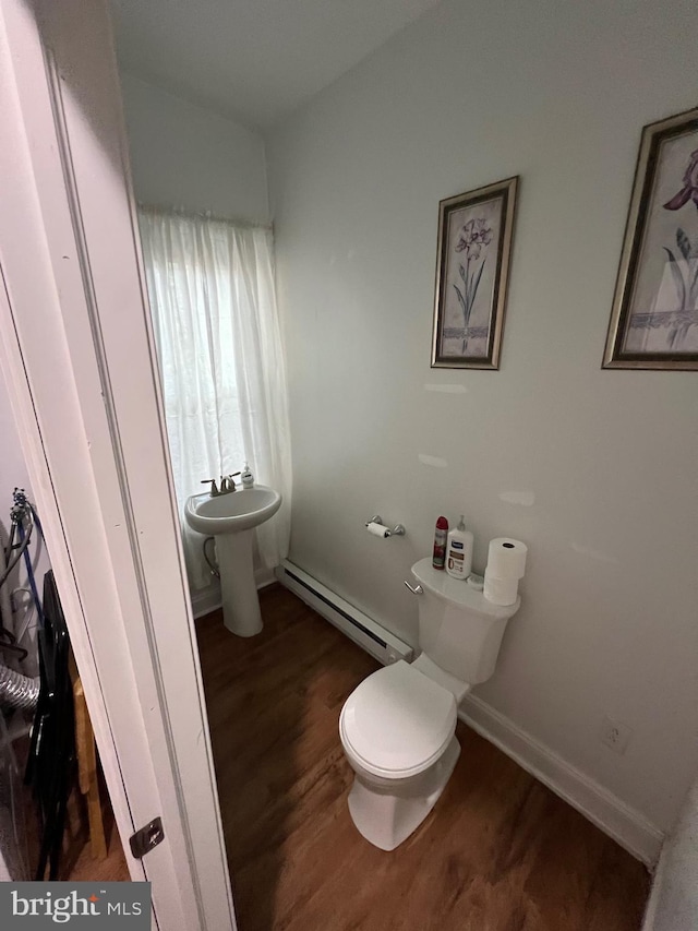 bathroom featuring toilet, baseboard heating, sink, and hardwood / wood-style flooring