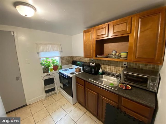 kitchen with electric stove, light tile patterned floors, backsplash, and sink