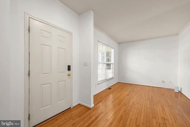 foyer entrance featuring crown molding and light hardwood / wood-style flooring