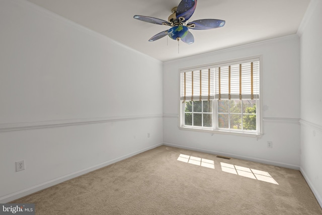 carpeted empty room with ceiling fan and crown molding