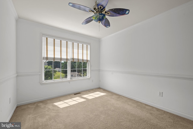 carpeted empty room featuring ceiling fan and crown molding