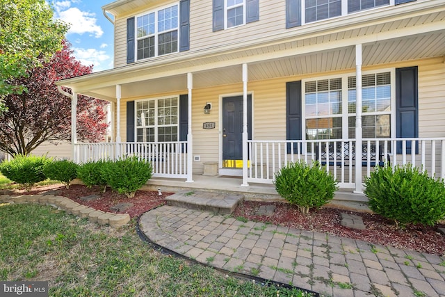 view of exterior entry featuring covered porch