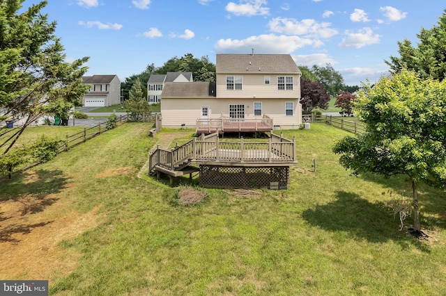 rear view of property featuring a wooden deck and a yard