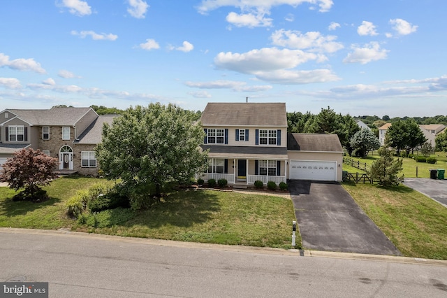 view of front of home featuring a front lawn, covered porch, and a garage