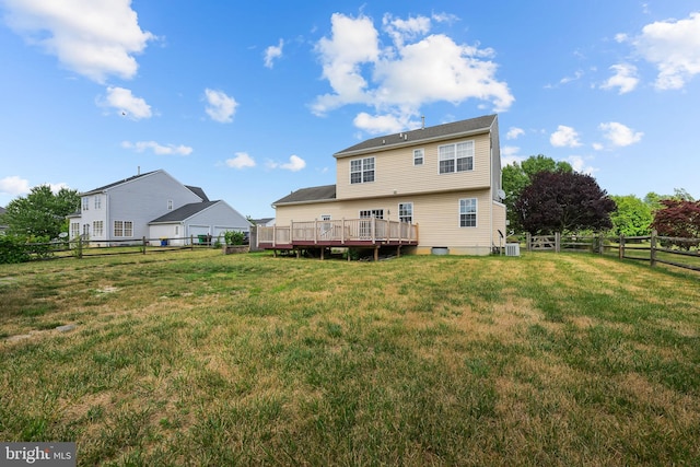 rear view of house with a deck and a yard