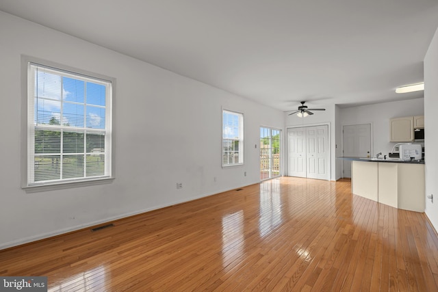 unfurnished living room with ceiling fan and light wood-type flooring