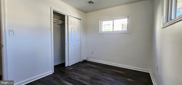 unfurnished bedroom featuring dark hardwood / wood-style floors and a closet