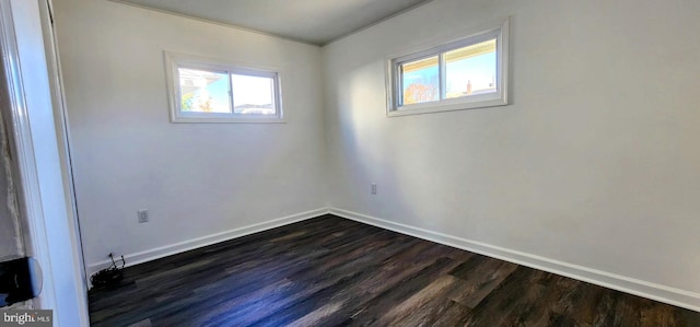 empty room featuring dark wood-type flooring and a wealth of natural light