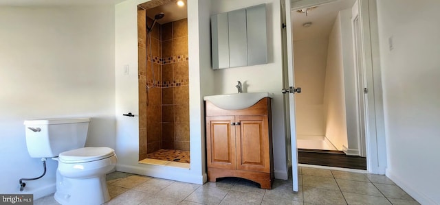 bathroom featuring a tile shower, vanity, toilet, and tile patterned floors