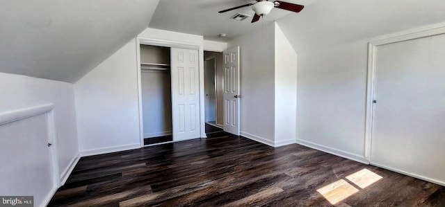 unfurnished bedroom with lofted ceiling, dark hardwood / wood-style flooring, ceiling fan, and a closet