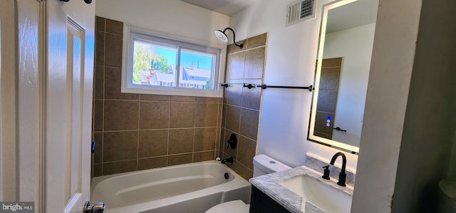 full bathroom with tiled shower / bath, vanity, and toilet