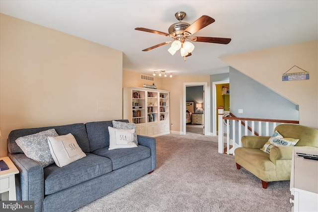 living room featuring baseboards, carpet floors, visible vents, and a ceiling fan