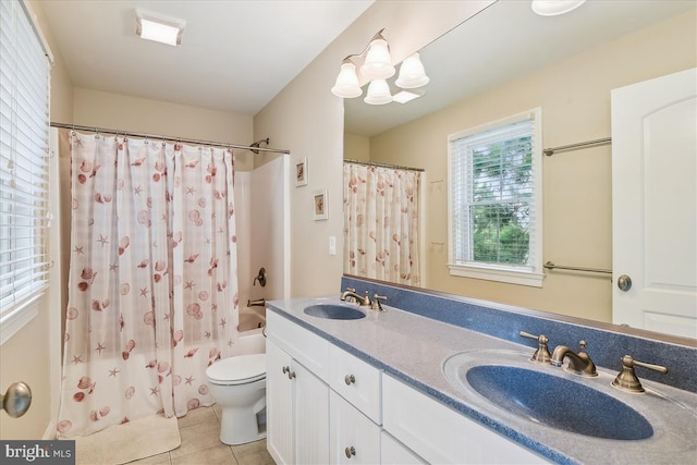 bathroom featuring toilet, double vanity, a sink, and tile patterned floors