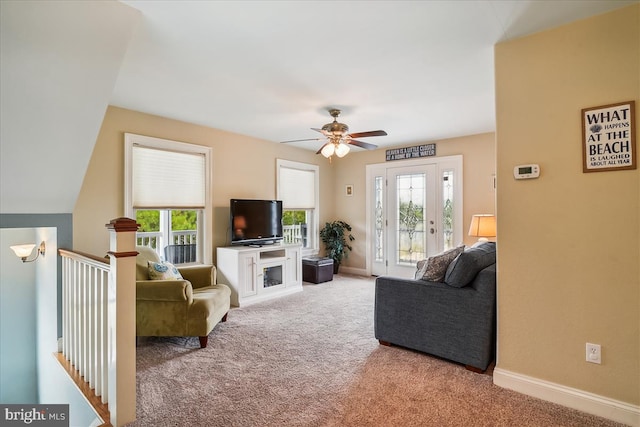 carpeted living room with baseboards and a ceiling fan