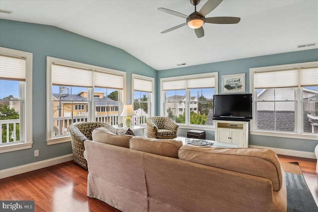 living room featuring lofted ceiling, dark wood-style floors, visible vents, and a wealth of natural light