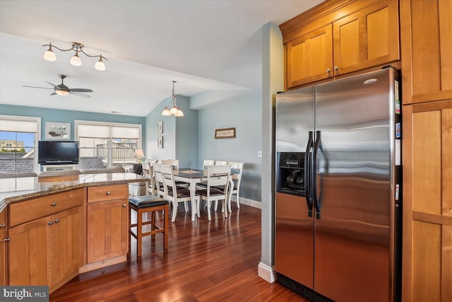 kitchen featuring a ceiling fan, stainless steel fridge, dark wood finished floors, and brown cabinets