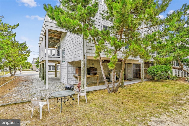 back of property featuring cooling unit, fence, and a lawn