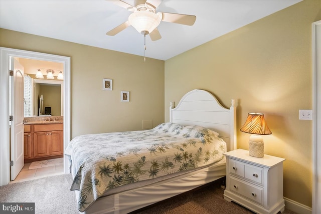 tiled bedroom featuring connected bathroom and ceiling fan